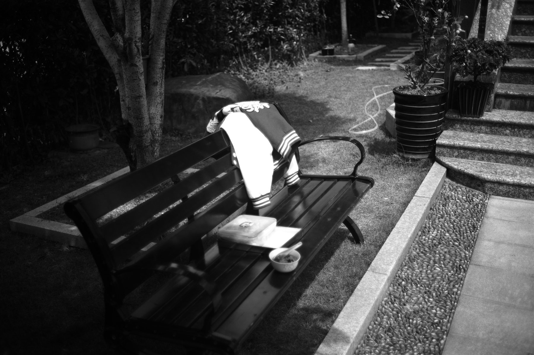 A lunch box left on a bench in a garden