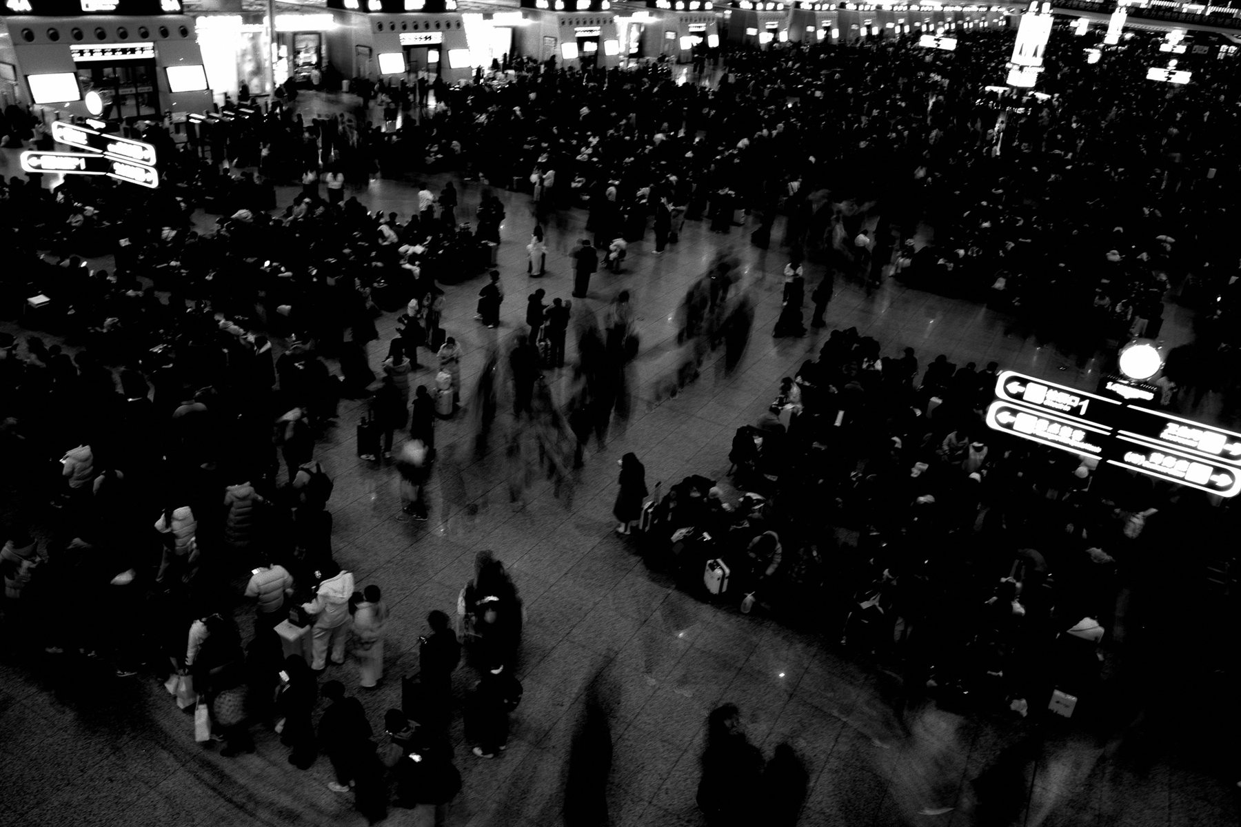 A crowded train station concourse seen from above